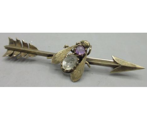 Victorian style unmarked rose tone metal fly bar brooch in the form of an arrow, central fly set with amethyst and clear ston
