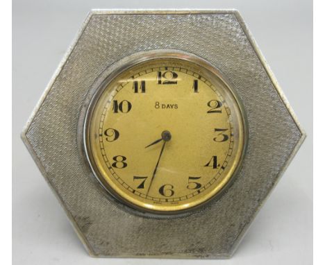 Art Deco silver 8-day travelling bedside clock, silvered dial with black Arabic numerals, blued steel hand and hexagonal engi