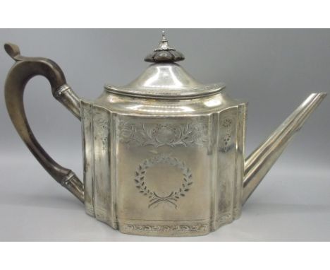 George III silver teapot of oval panelled form, tapered straight spout, body decorated with central wreath and scrolling foli