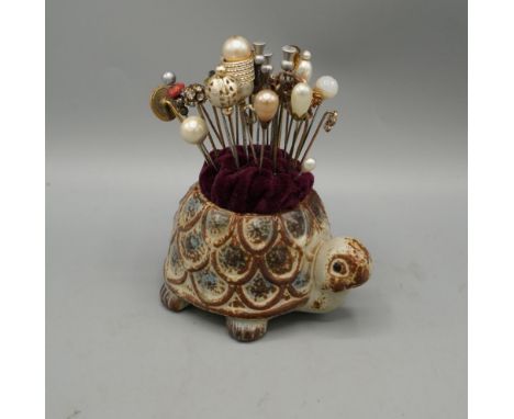 Collection of vintage hat and tie pins many with costume jewel and pearl finials, in a ceramic tortoise pin cushionShipping £
