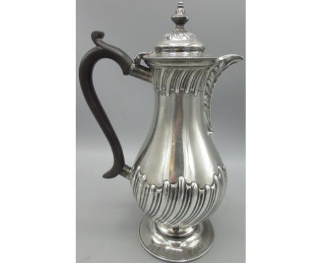 Victorian silver hot water jug in baluster form, part lobed body, acanthus leaf repousse to spout, ebonised handle and urn sh
