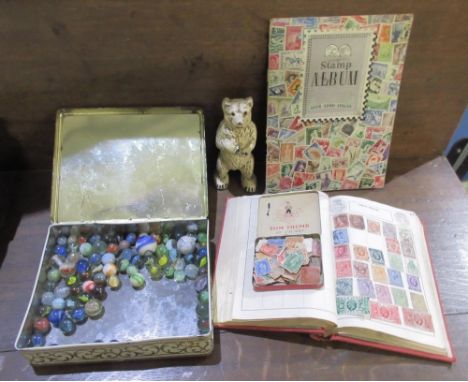 Approx. 80 vintage glass marbles, cast metal Polar Bear money box, schoolboy album of post Victorian All World stamps, incl. 