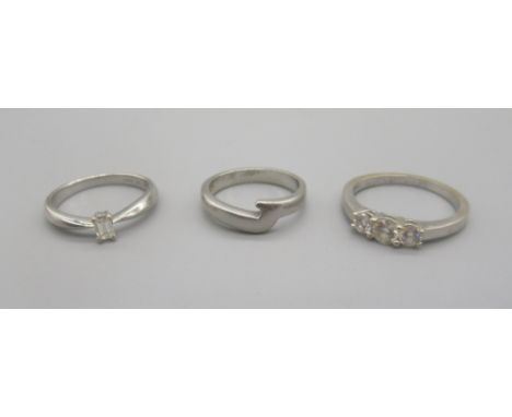18ct diamond solitaire ring set with baguette cut diamond, stamped 750, size I1/2, 2.47g, a white metal three stone diamond r