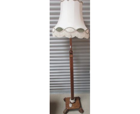 Art Deco oak standard lamp, turned and fluted column on square base with four scroll feet, later fringed shade, H190cmShippin