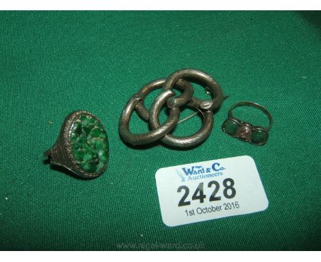 A Victorian Silver Knot Brooch and two oriental Silver Rings, one with carved jade.