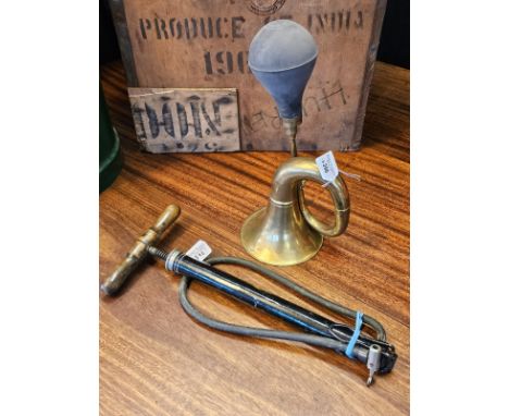 A vintage style brass bulb horn together with a black enamel stirrup tyre pump. (2) (B.P. 21% + VAT)