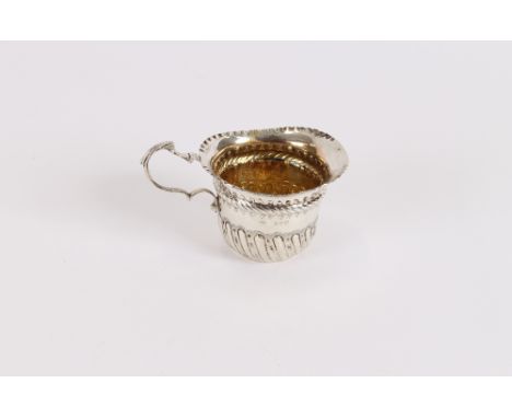A late Victorian silver baluster cream jug, having fluted decoration, C scroll handle and gilded interior, London 1890
