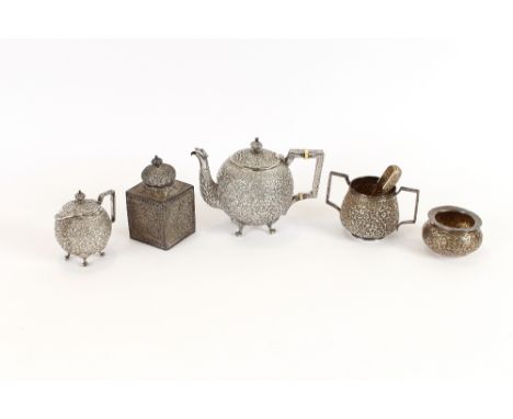 An Indian white metal teapot, of bullet shape, profusely decorated with foliate scrolls, beast head spout and angular handle 