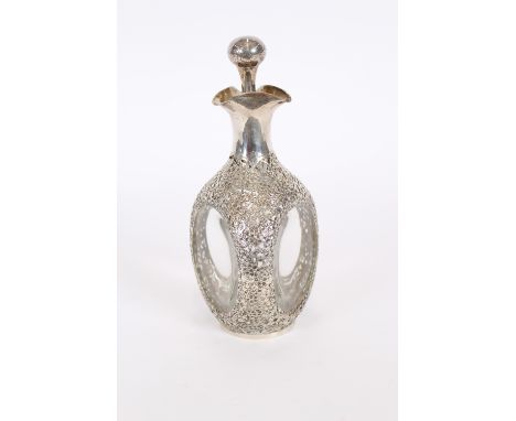 A Haig dimpled decanter, overlaid with white metal profuse foliate decorated mounts and baluster stopper, 27.5cm high