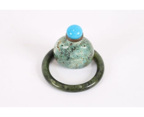 A Chinese spinach green jade bangle, of circular form; and a Chinese hardstone snuff bottle and stopper, (2)