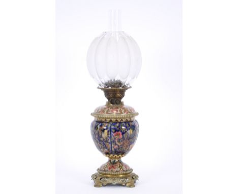 A Zsolnay Pecs table oil lamp, the baluster base with lift-out reservoir and raised on an oriental style pierced brass stand,