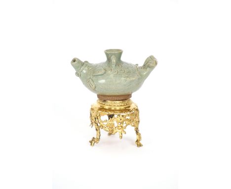 A small celadon fish shaped oil lamp, 11cm long; together with an associated Amsterdam gilded stand with swag decoration