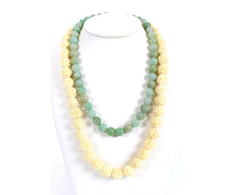 A pale jade necklace, 43cm long; jade panel ring set to a 14 carat gold mount; and a carved ivory necklace, (2)