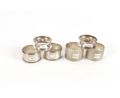 A pair of silver engine turned decorated napkin rings, by Edwin Viner, (initialled); a smaller similar pair; and two others, 