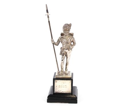 A silver "Battle of Waterloo" commemorative figure of a soldier, mounted on a black wood plinth, with plaque inscribed 1815, 