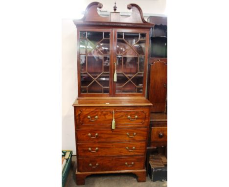 A George III mahogany secretaire bookcase, of small proportions, the upper section surmounted by a swan arch pediment and cen