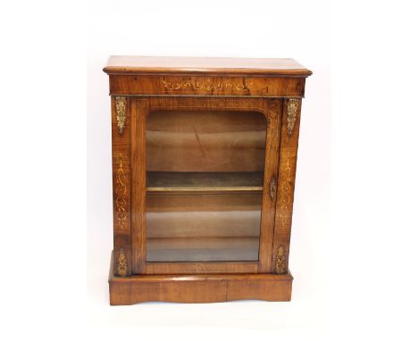 A Victorian walnut and inlaid pier cabinet, having gilt metal embellishments, glazed arched panel door enclosing fabric lined