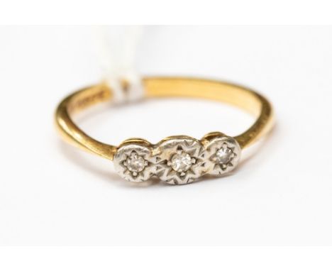 A three stone diamond ring illusion set in 18ct gold stamped, size K, with a total gross weight of approx 2.2gms