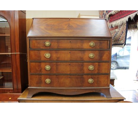 An Edwardian mahogany bureau, the fall enclosing a fitted interior with drawers, pigeon holes and two inset inkwells, the bas