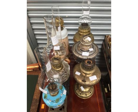 A collection of seven oil lamps to include two with cast iron base, two ceramic lamps, two brass and a silvered example (7) 