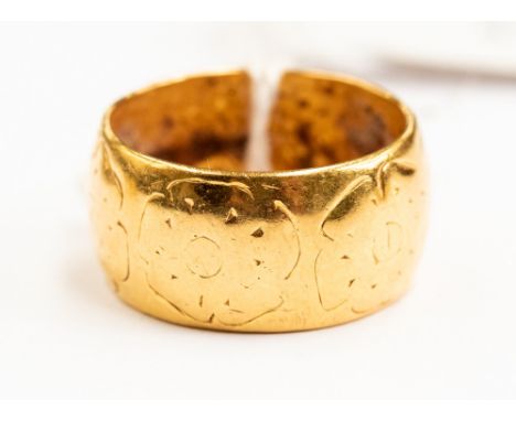 A 22ct gold patterned wedding band, engraved flower pattern, size O, weight approx 11.9 grams 