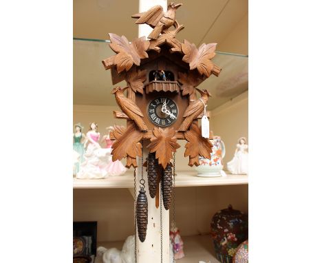 A carved Black Forest clock with dancing people 
