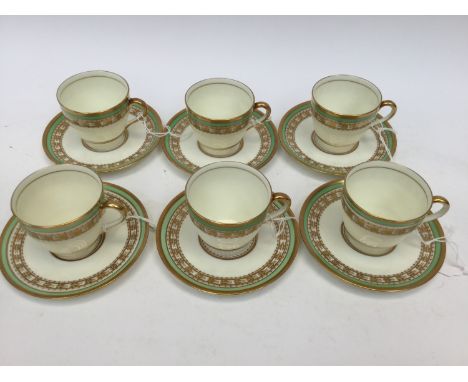 A Royal Doulton part coffee set, comprising six cups and six saucers, each decorated with gold and green rims, no. to base B3