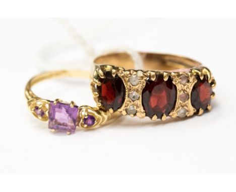 A garnet three stone 9ct gold dress ring, size R,  together with an amethyst 9ct gold dress ring, size O, (2) 