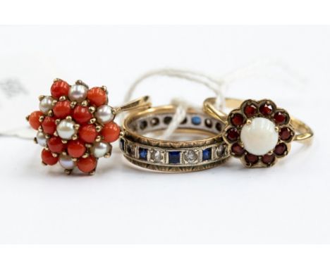 A collection of three 9ct gold rings, comprising a garnet and opal set flower cluster, a pearl and coral cluster ring and a s