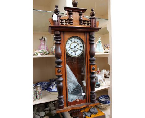 A 19th Century eight day Vienna wall clock, with white enamelled dial and black Roman numerals, the door with split turned co