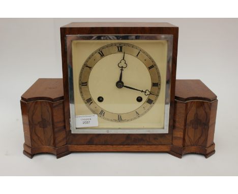 An Art Deco walnut eight day mantle clock, having a square dial, two winder holes, striking on a gong