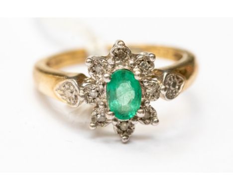 An emerald and diamond flower cluster ring, set with an oval emerald to the centre, with a border of claw  illusion set diamo