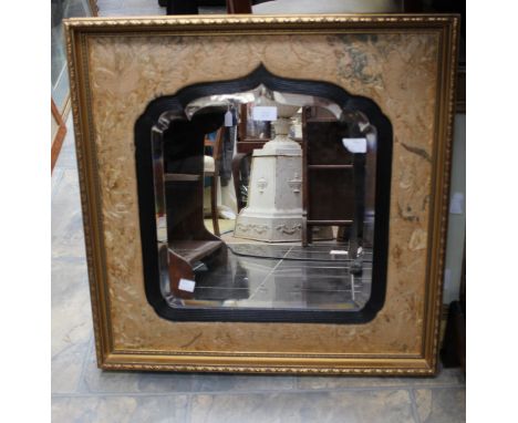 A bevelled wall looking glass set into an embroidered cushion surround, recent gilt frame, 64cm by 64cm 