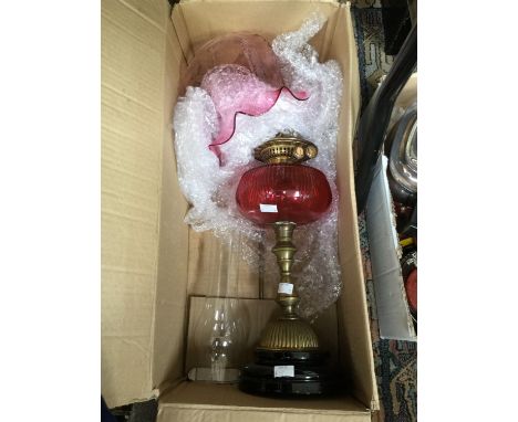 An early 20th Century oil lamp, chimney, cranberry glass reservoirs and pink shade 