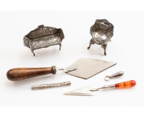 A silver bladed trowel; together with similar smaller trowel bookmark, a miniature silver sofa and chair and two small items 