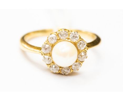 A cultured pearl and diamond cluster ring, set in yellow metal tests as 18ct gold, central pearl measuring approx 5.5mm, with