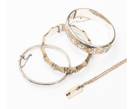 A collection of silver items comprising three silver bangles, one circa 1960s bamboo bangle, one engraved bangle with rose go