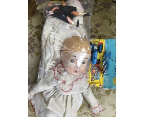 A three faced bisc head doll, with a further bisc head doll (one foot broken) and a small composite doll, boxed Corgi tractor