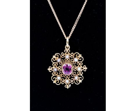 A yellow metal seed pearl and pink stone possibly tourmaline brooch with ornate open work,  the pink stone set to the centre 