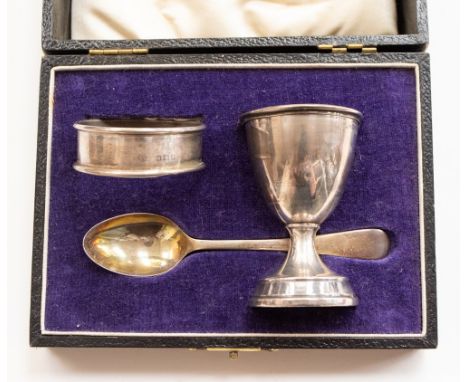 A cased silver christening set, comprising egg cup, serviette and teaspoon, the first two by Wolfsky & Co., London 1930, the 
