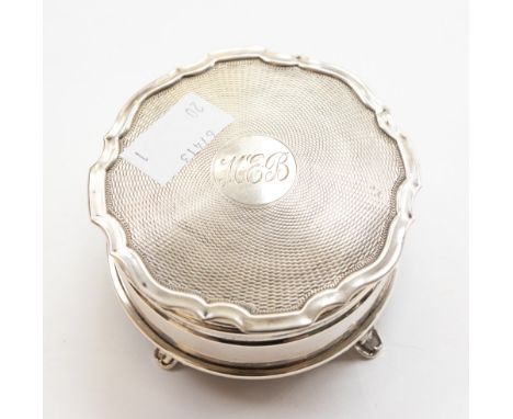 An Elizabeth II silver ring box, engine turned cover with pie crust rim, plain body on four scroll feet, silk lined interior,