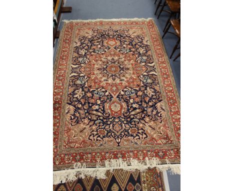 A Turkish Kayseri hand knotted wool-on-cotton rug/carpet with stylised symmetrical floral decoration on blue ground, red bord