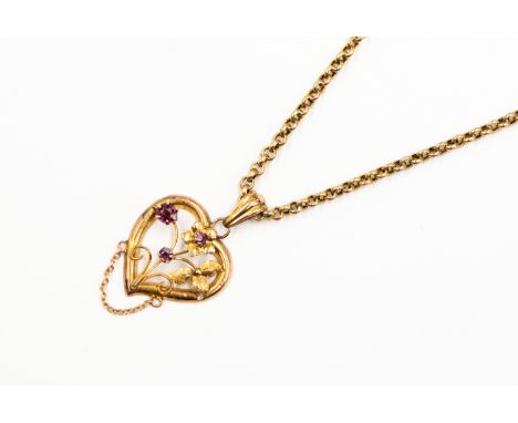 A 9ct gold stamped amethyst heart shaped pendant, with open work and faceted purple paste stones with floral and leaf decorat