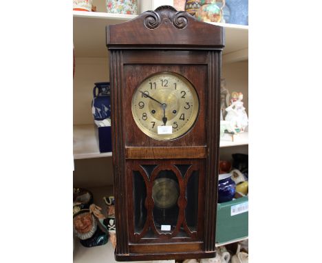 A 1940s oak cased drop dial clock, key and pendulum 