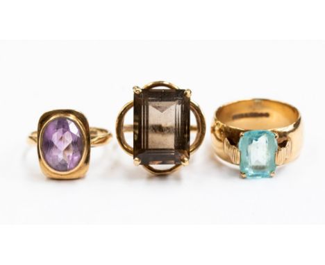 Three 9ct gold rings, one set with cushion shaped blue topaz, one set with rectangular cut smoky quartz, and one set with an 