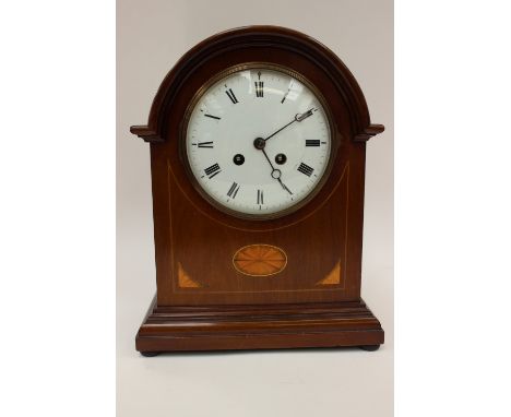 A George V mahogany and boxwood inlaid eight day mantle clock, with a white enamelled dial and two winder holes, striking on 