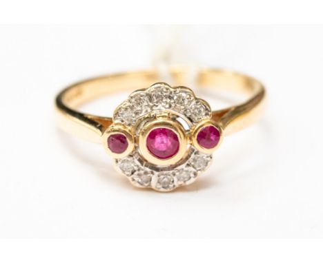 An Art Deco style ruby and diamond ring, set with three rubies with a halo of diamonds, 18ct gold, size O½, total gross weigh