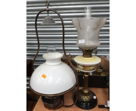 An oil lamp with floral glass reservoir and etched shade, together with a  hanging oil lamp with white glass shade (2)