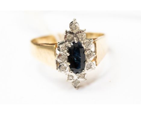 An gold ring (indistinct hallmark, possibly 18ct) set in Art Deco style, sapphire to the centre surrounded with illusion set 