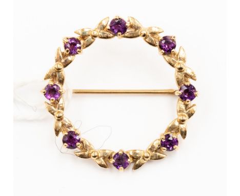 A yellow metal, probably 9ct gold, amethyst brooch, with round stone and interspaced cross detail, approx 4gms